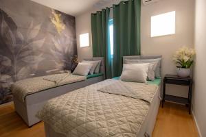 2 letti in una camera con tende verdi di Geek Penthouse a Makarska