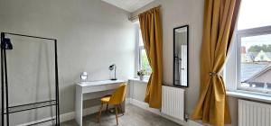 een badkamer met een gele stoel, een wastafel en een raam bij Habershon by Switchback Stays in Cardiff +46 foto's