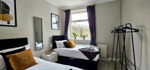 een slaapkamer met twee bedden en een raam bij Habershon by Switchback Stays in Cardiff