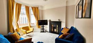 een woonkamer met een blauwe bank en een tv bij Habershon by Switchback Stays in Cardiff