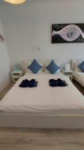 uma grande cama branca com duas almofadas azuis em Herczeg Udvarház Poroszló em Poroszló