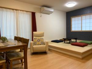 uma sala de estar com um sofá, uma cadeira e uma mesa em Guesthouse Kaede Annex em Nara