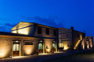 un viejo edificio de ladrillo con luces encendidas por la noche en Moretti Village - B&B en Civitanova Marche