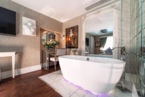 a bathroom with a large white tub in a room at Karma Sanctum Soho Hotel in London