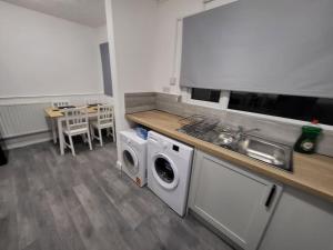 a kitchen with a sink and a washing machine at 3 Bed House, free parking. Great for work crews - Stay Sleep Rest in Nottingham