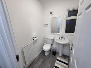 a white bathroom with a toilet and a sink at 3 Bed House, free parking. Great for work crews - Stay Sleep Rest in Nottingham