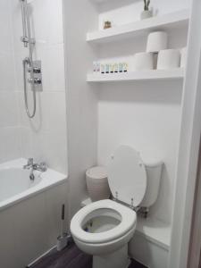 uma casa de banho branca com um WC e um lavatório em Heronsgate GH015 em Gravesend