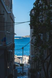 a view of the ocean from between two buildings at Hayes suite syros in Ermoupoli
