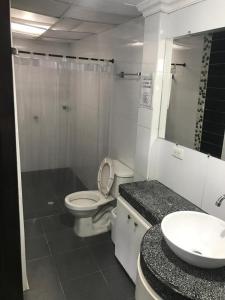 a bathroom with a toilet and a sink and a mirror at Hotel Colonial - Salamina Caldas in Salamina