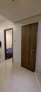 um quarto com uma porta de madeira e um espelho em 2 Bedroom with Balcony/ Family Room em Manila