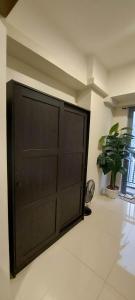 una gran puerta de madera en una habitación con una planta en 2 Bedroom with Balcony/ Family Room en Manila