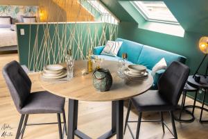 a table in a room with chairs and a couch at Le Clos du Rempart Suite & Jacuzzi in Ciney