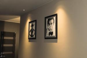 twee ingelijste foto's van een man aan een muur bij Le Clos du Rempart Suite & Jacuzzi in Ciney