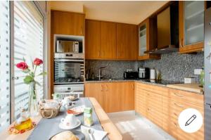 a kitchen with wooden cabinets and a table with a vase of flowers at BEAUTIFUL ROOM RIVER in Anglés