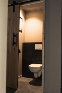 een badkamer met een toilet via een deur bij Le Clos du Rempart Suite & Jacuzzi in Ciney