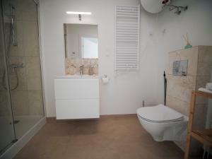 een witte badkamer met een toilet en een douche bij Pogodne domki in Swarzewo