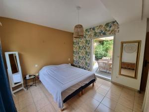 a bedroom with a bed and a door to a patio at Villa spacieuse Piscine, terrain de petanque in Villeveyrac