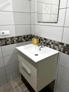 La salle de bains est pourvue d'un lavabo blanc et d'un miroir. dans l'établissement Bluebell L6, à Armeñime