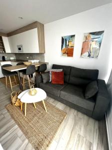 un salon avec un canapé noir et une cuisine dans l'établissement Bluebell L6, à Armeñime
