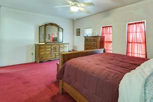 ein Schlafzimmer mit einem Bett, einem Spiegel und einer Kommode in der Unterkunft Remote Pet-Friendly Harlingen House! in Harlingen