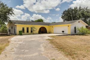 a yellow and white house with a garage at Remote Pet-Friendly Harlingen House! in Harlingen
