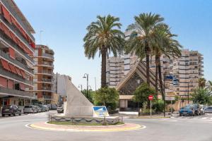 ein Denkmal inmitten einer Straße mit Palmen in der Unterkunft View of the sea Beach 50 meters in Sueca