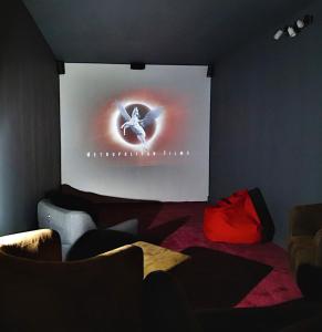 una pantalla de proyección en una habitación oscura con sillas en Chalet with Ski Slope Views, Jacuzzi & Cinema Room en Vars