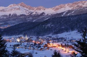 a town in the snow at night with snow covered mountains at Appartement Balcon Villard-de-lans in Villard-de-Lans