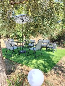 a picnic table and chairs under a tree at CASINA DAMÍ in Canosa Sannita