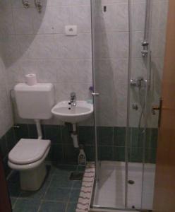 uma casa de banho com um WC, um chuveiro e um lavatório. em Room 400 m from the beach em Izola