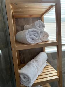 a pile of towels on a shelf in a bathroom at The Pier Suite Serviced Apartment Blackpool in Blackpool