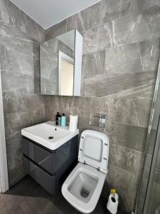 a bathroom with a sink and a toilet and a mirror at The Pier Suite Serviced Apartment Blackpool in Blackpool