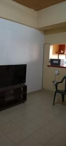 Habitación con TV de pantalla plana y silla. en Akira Safaris Furnished Apartment, en Migori