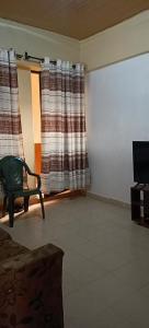 a living room with a chair and a television at Akira Safaris Furnished Apartment in Migori