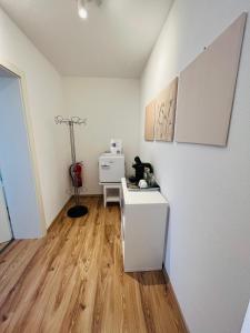 een kamer met een witte koelkast en een houten vloer bij Appartement Seehof in Nassereith