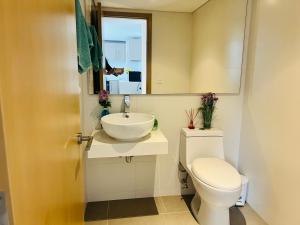 a bathroom with a toilet and a sink and a mirror at Apartamento piso 41 VIP Hermosa vista en Bogotá in Bogotá
