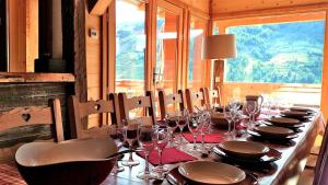 una mesa larga con copas de vino y servilletas. en Chalet with Ski Slope Views, Jacuzzi & Cinema Room en Vars