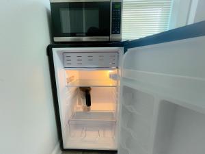 a microwave sitting on top of an open refrigerator at Beautiful room in prime location in Pinellas Park