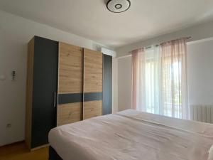 een slaapkamer met een groot wit bed en een raam bij MarAzul Apartments in Povljana