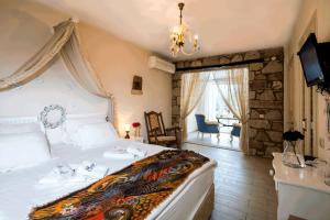 una camera da letto con un grande letto e un lampadario a braccio di Alaçatı Sultan Konak Butik Otel ℳℛ Luxury Concept ad Alaçatı