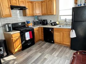 a kitchen with wooden cabinets and black appliances at Kennedy House on Melrose Ave in Atlantic City