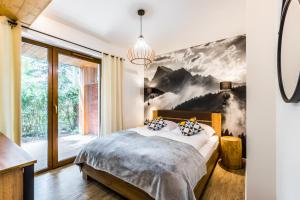 een slaapkamer met een bed en een groot raam bij Rezydencja Za Strugiem in Zakopane