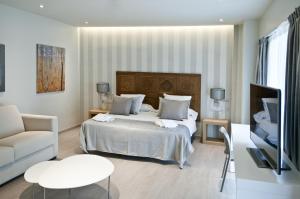 バルセロナにあるセレンニア エクスクルーシヴルームズのベッドルーム1室(ベッド1台、ソファ、テーブル付)
