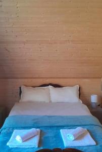 a bed with two towels sitting on top of it at Cottage Mzispira/Cottage sunny side in Sioni