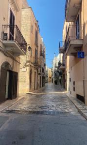una strada vuota in un vicolo tra due edifici di Le Dimore del Casalvecchio a Conversano