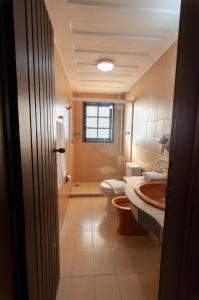 a bathroom with two toilets and a sink and a shower at Buzios Arambaré Hotel in Búzios