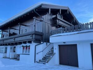 a building with a balcony and a garage in the snow at Brandner Astn in Krimml