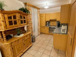 uma cozinha com armários de madeira e uma bancada em Brandner Astn em Krimml