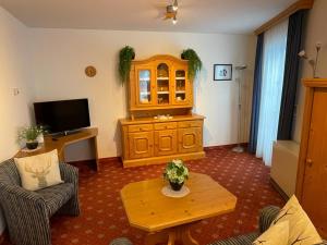 uma sala de estar com um armário de madeira e uma mesa em Brandner Astn em Krimml