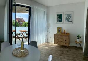 a white living room with a table and a balcony at Ap-art-mán 08 in Mikulov